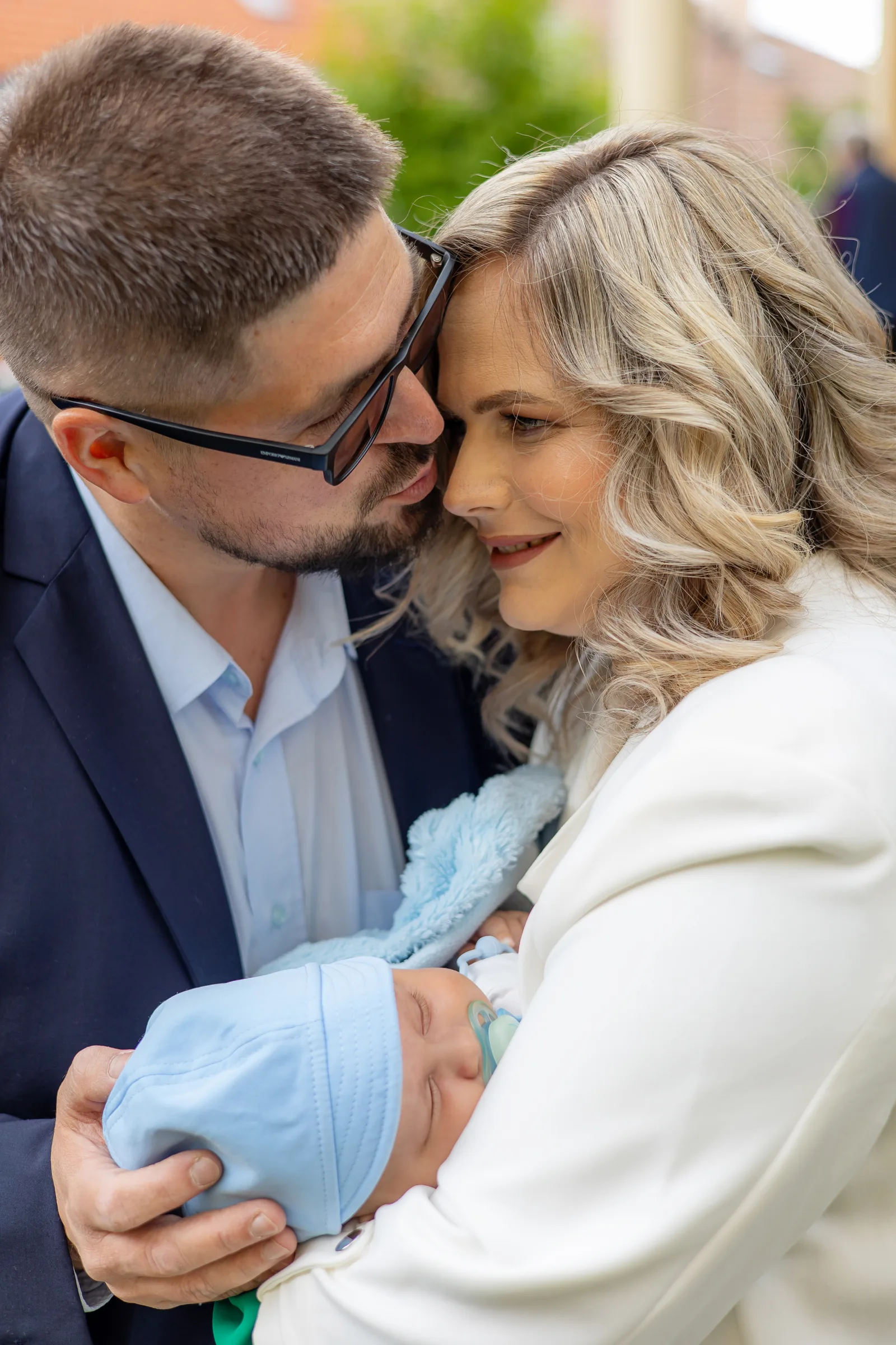 Botezul lui Alex — botez rochelle cluj alex tata mama saruta bebelus exterior — fotograf botez