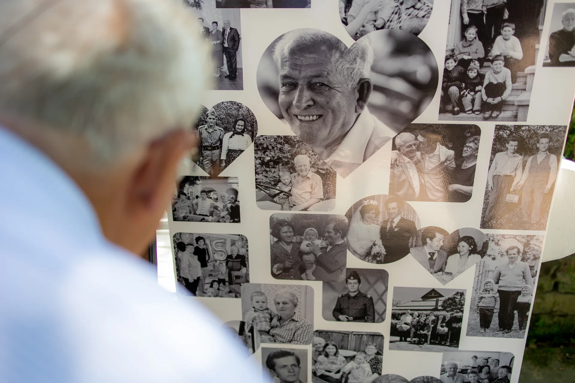 Ședințe foto familie Cluj-Napoca — bărbat privește colaj memorial cu fotografii de familie