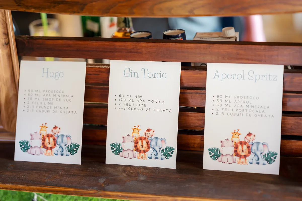 Detaliu cu meniul de cocktailuri la botezul de la La Moșu — Hugo, gin tonic și Aperol, pe masă în aer liber lângă Cluj-Napoca