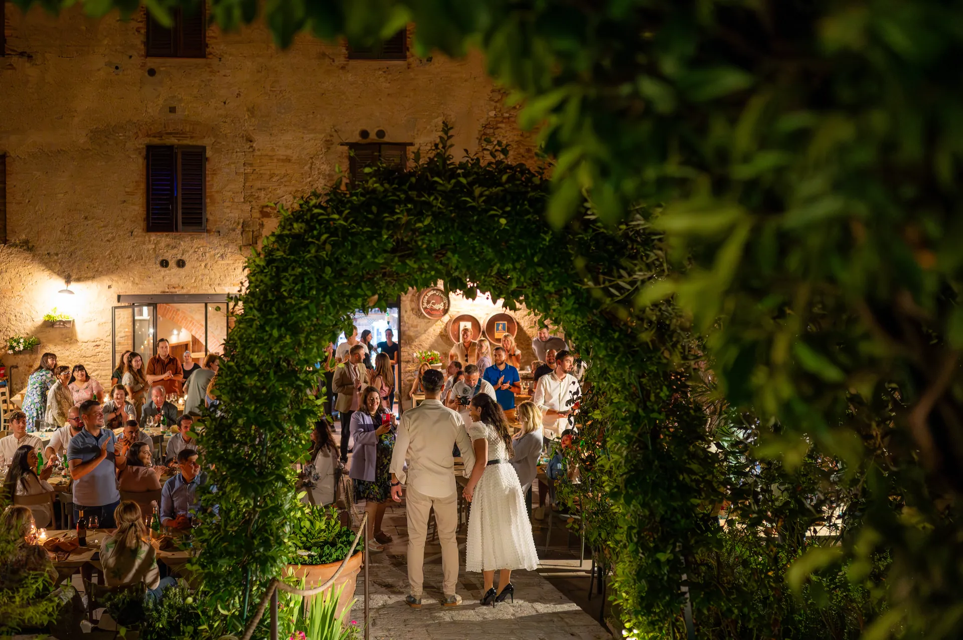 Roxana & Ionuț — nunta toscana italia roxana ionut cuplu arcada iederă invitati aplauze — fotograf nuntă